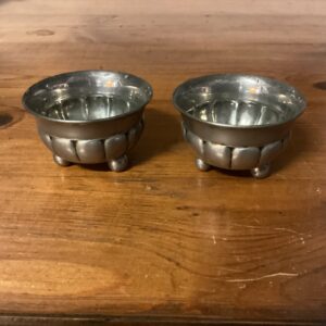 Et par runde saltkar i tin stående på 3 ben